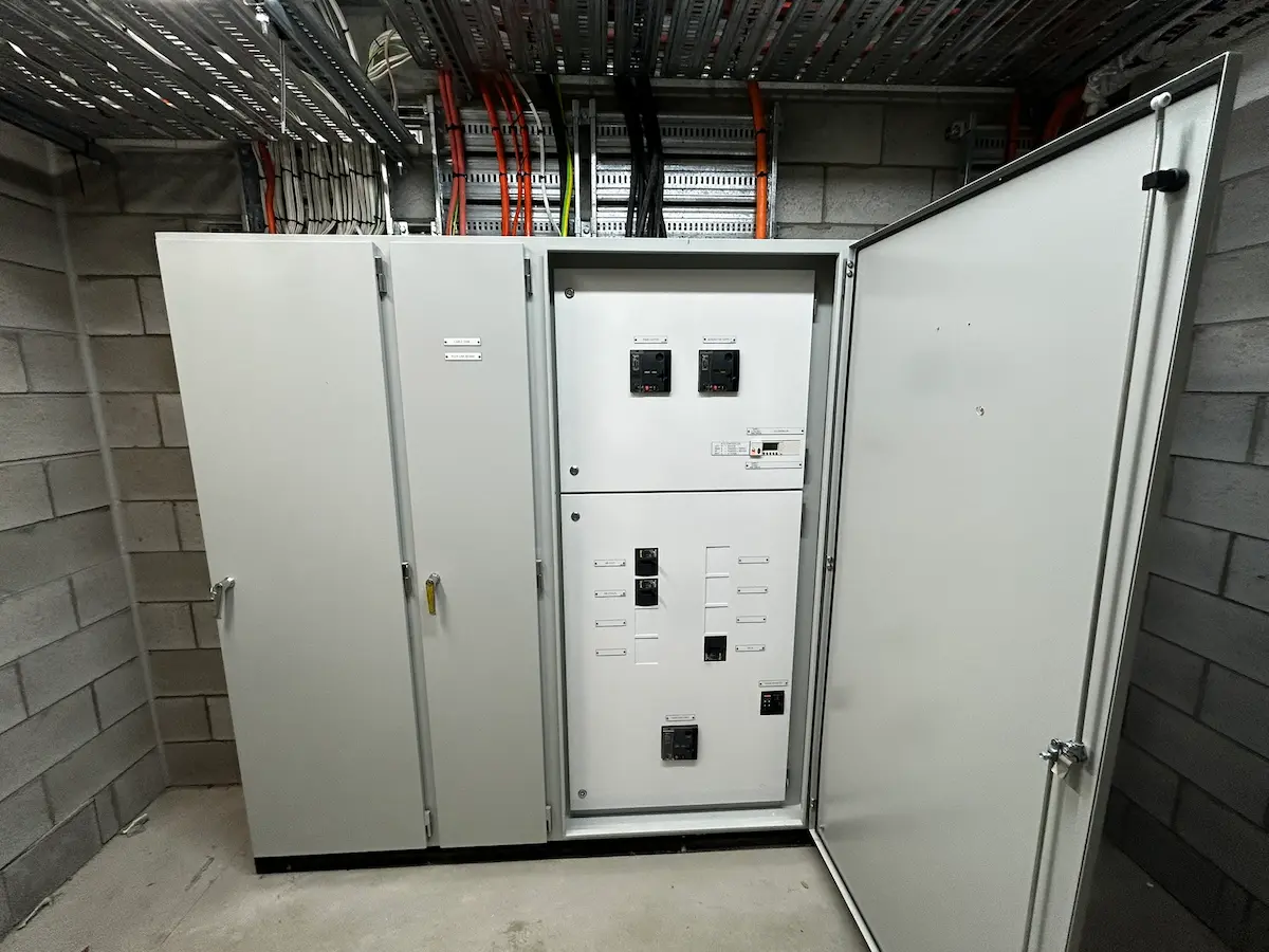 Row of new commercial switchboard cabinets installed in a plant room