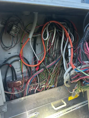 Tangled cable tails in the bottom of an ageing commercial switchboard cabinet