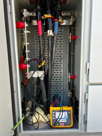 Fluke 1738 power logger connected for a three-phase load study in a switchboard